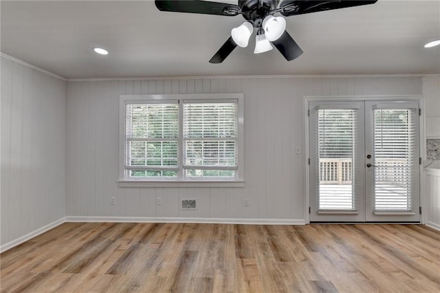 unfurnished room featuring light hardwood / wood-style floors, french doors, and crown molding