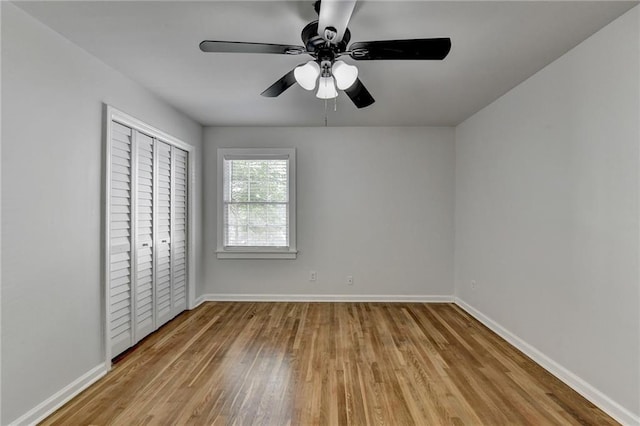 unfurnished bedroom featuring a closet, light hardwood / wood-style floors, and ceiling fan