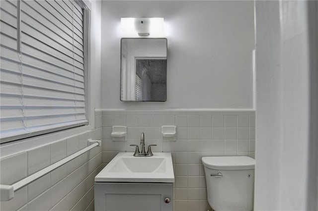 bathroom with tile walls, vanity, and toilet