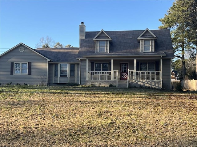 view of front facade featuring a porch, a front yard, and a chimney