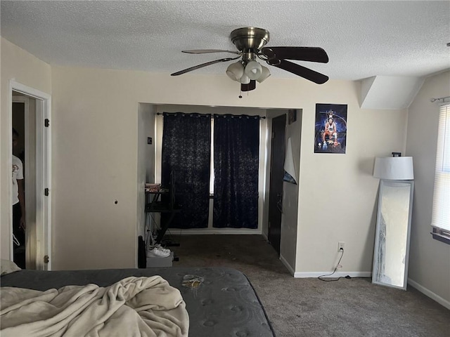 bedroom featuring ceiling fan, carpet, baseboards, and a textured ceiling