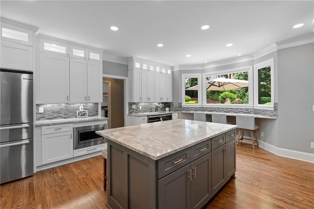 2510 Wood Creek Ct, Dacula, GA 30019 - kitchen with appliances with stainless steel finishes, crown molding, white cabinetry, decorative backsplash, and light stone counters