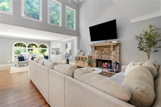 2510 Wood Creek Ct, Dacula, GA 30019 - living area with a high ceiling, a fireplace, light wood-style flooring, crown molding, and baseboards