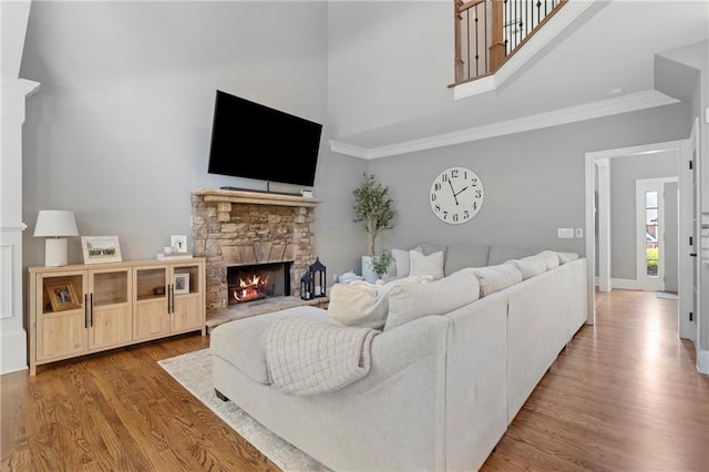 2510 Wood Creek Ct, Dacula, GA 30019 - living room with a towering ceiling, a stone fireplace, ornamental molding, wood finished floors, and baseboards