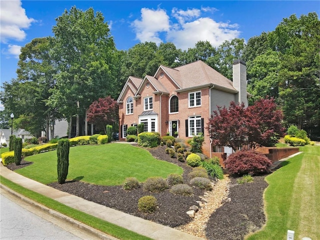 2510 Wood Creek Ct, Dacula, GA 30019 - colonial inspired home featuring a front lawn, a chimney, and brick siding