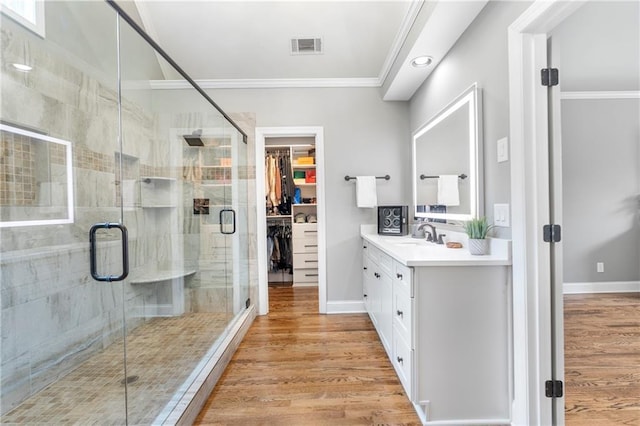 2510 Wood Creek Ct, Dacula, GA 30019 - full bathroom with vanity, ornamental molding, a stall shower, wood finished floors, and a spacious closet