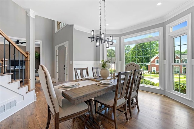 2510 Wood Creek Ct, Dacula, GA 30019 - dining area with crown molding, stairs, dark wood-style flooring, and a chandelier