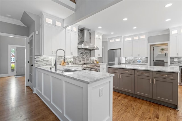 2510 Wood Creek Ct, Dacula, GA 30019 - kitchen featuring wall chimney range hood, ornamental molding, a sink, appliances with stainless steel finishes, and decorative backsplash