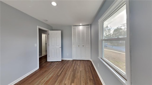 unfurnished bedroom featuring dark hardwood / wood-style floors and a closet