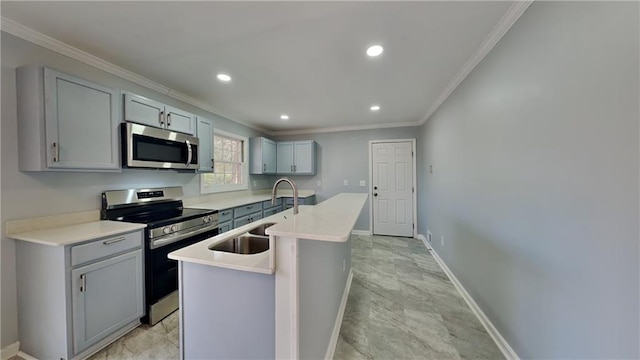 kitchen featuring sink, gray cabinetry, ornamental molding, an island with sink, and stainless steel appliances