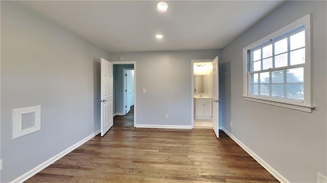 unfurnished bedroom featuring dark wood-type flooring and connected bathroom