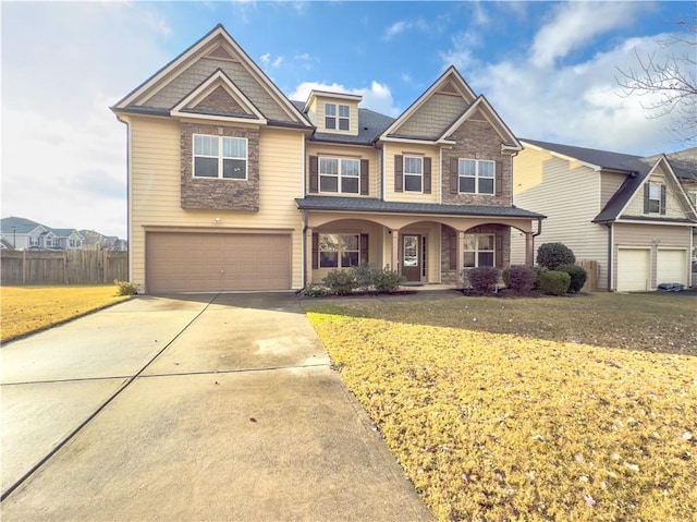 view of front of house featuring a porch, a garage, and a front lawn