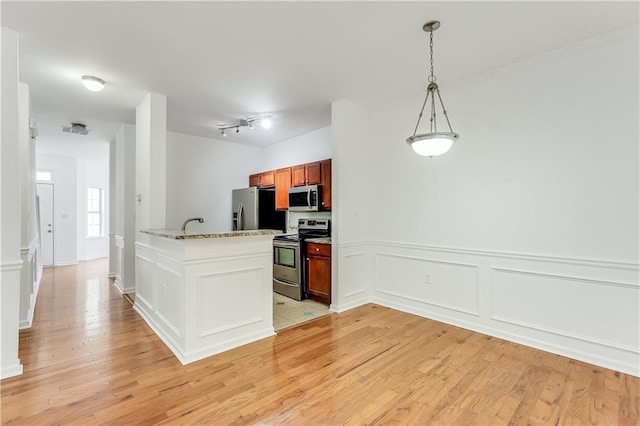2520 Laurel Cir NW, Atlanta, GA 30311 - kitchen featuring stainless steel appliances, light wood-style floors, a peninsula, hanging light fixtures, and wainscoting