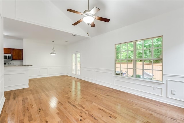 2520 Laurel Cir NW, Atlanta, GA 30311 - unfurnished living room with a ceiling fan, light wood-style flooring, a decorative wall, wainscoting, and lofted ceiling