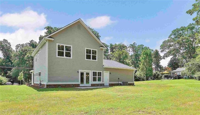 back of property featuring central air condition unit, french doors, and a lawn