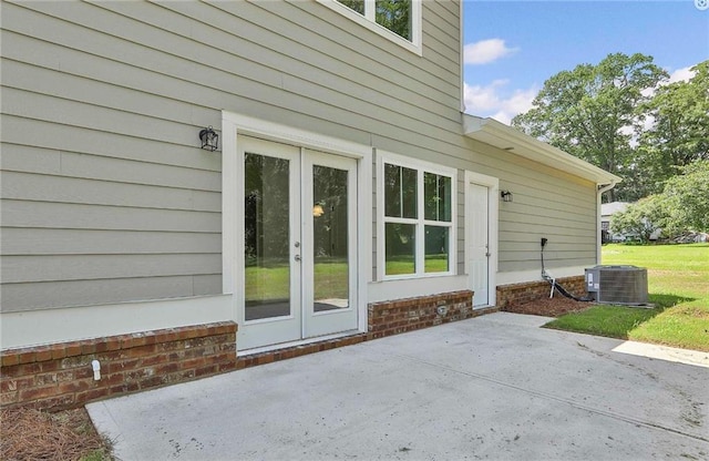 exterior space with a lawn, cooling unit, french doors, and a patio