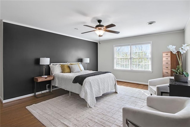 bedroom with hardwood / wood-style flooring, ornamental molding, and ceiling fan