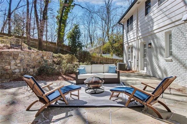 view of patio / terrace featuring central AC unit and an outdoor living space with a fire pit