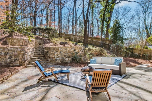 view of patio with an outdoor living space with a fire pit