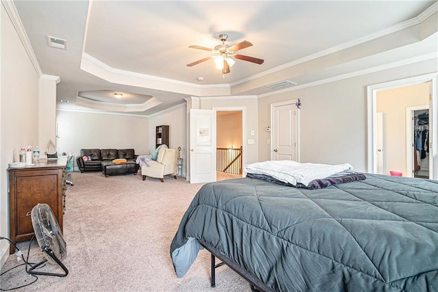 carpeted bedroom with ceiling fan, crown molding, a raised ceiling, and a closet