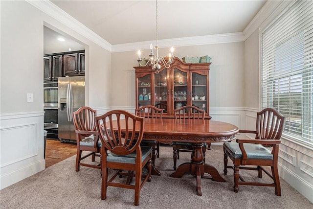 carpeted dining space featuring ornamental molding and a notable chandelier