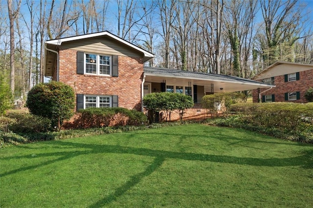 tri-level home featuring a front lawn, a carport, and brick siding