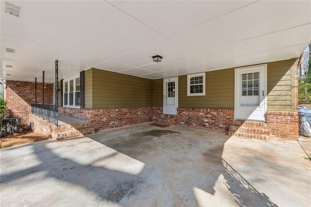 view of patio / terrace with visible vents, an attached carport, and entry steps