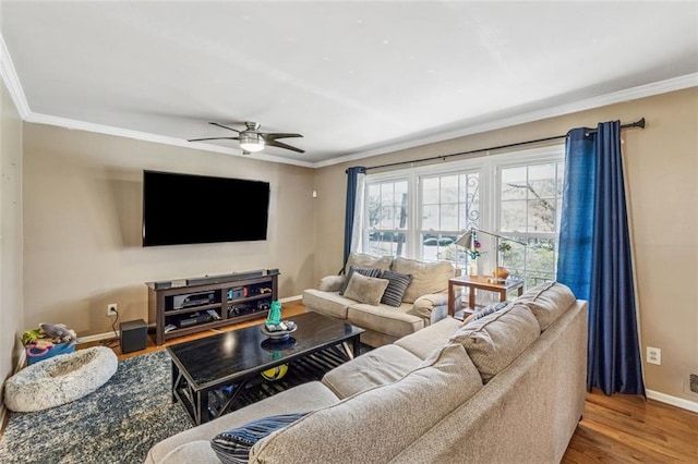 living room with ornamental molding, wood finished floors, baseboards, and ceiling fan