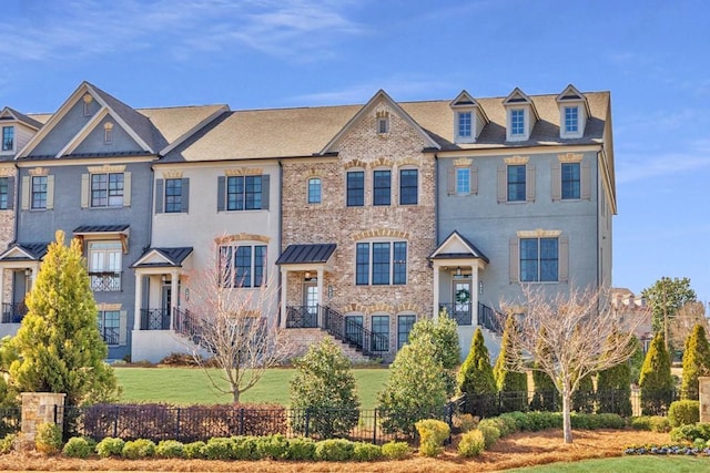 view of front of house with fence, a front lawn, and brick siding