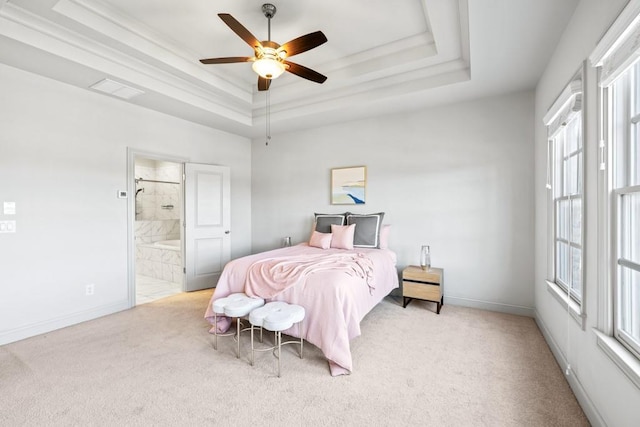 bedroom featuring carpet, a raised ceiling, ceiling fan, ensuite bath, and baseboards