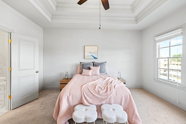 bedroom featuring light carpet, a ceiling fan, baseboards, and a tray ceiling