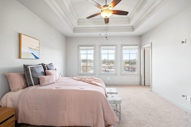 bedroom featuring light carpet, ornamental molding, a raised ceiling, and baseboards