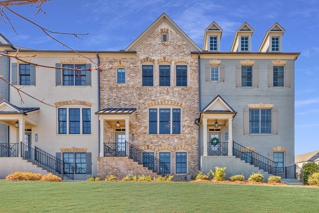 view of property featuring brick siding and a front yard