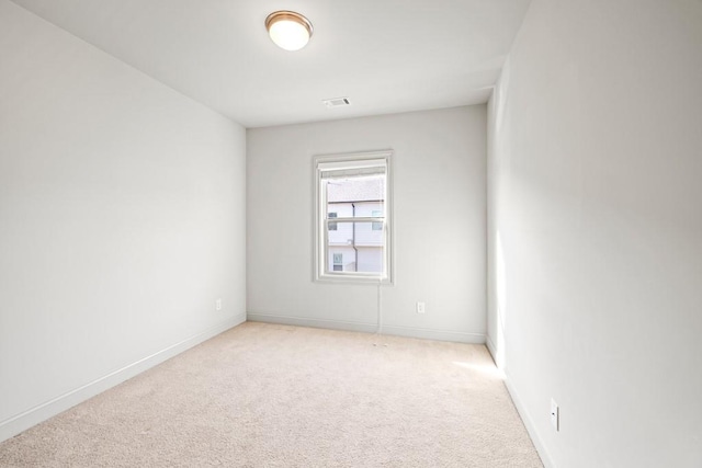 unfurnished room featuring light colored carpet, visible vents, and baseboards