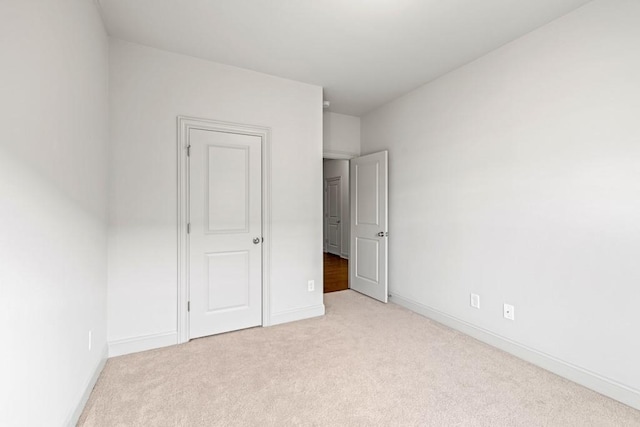 unfurnished bedroom with light carpet and baseboards