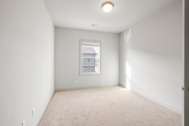 unfurnished room with carpet floors, visible vents, and baseboards