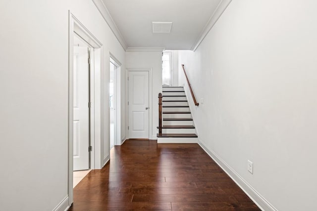 hallway with crown molding, visible vents, stairway, wood finished floors, and baseboards