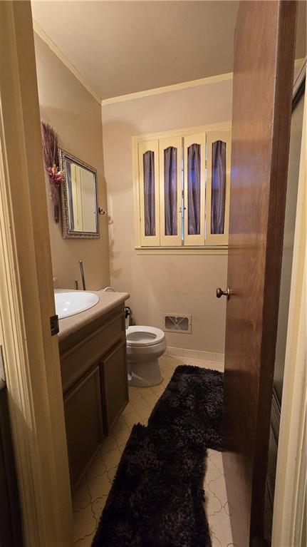 bathroom featuring tile patterned flooring, ornamental molding, vanity, and toilet