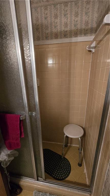 bathroom with tile walls, tile patterned floors, and walk in shower