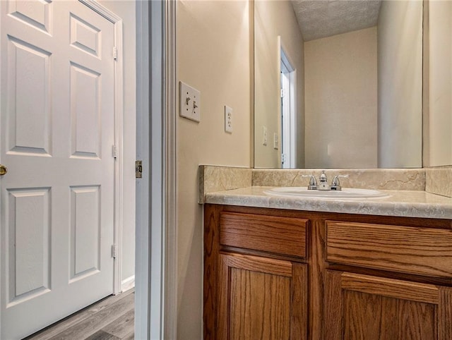 bathroom featuring vanity, a textured ceiling, and hardwood / wood-style flooring