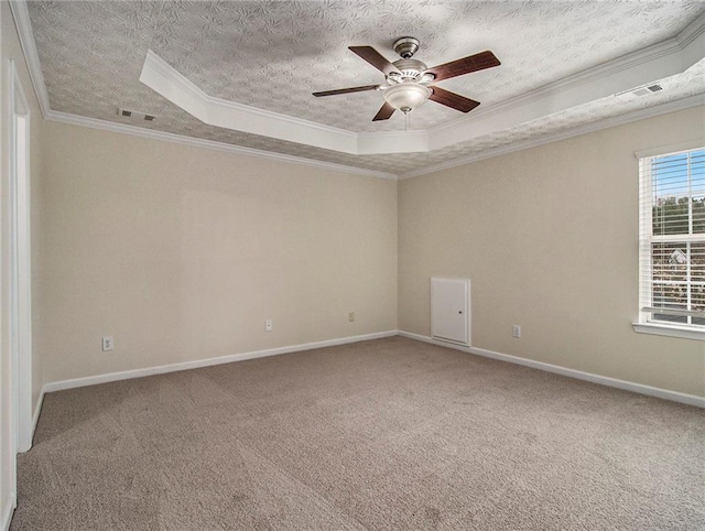 carpeted empty room with a tray ceiling, ceiling fan, and ornamental molding