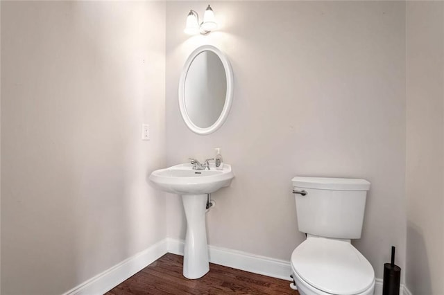 bathroom featuring baseboards, toilet, and wood finished floors