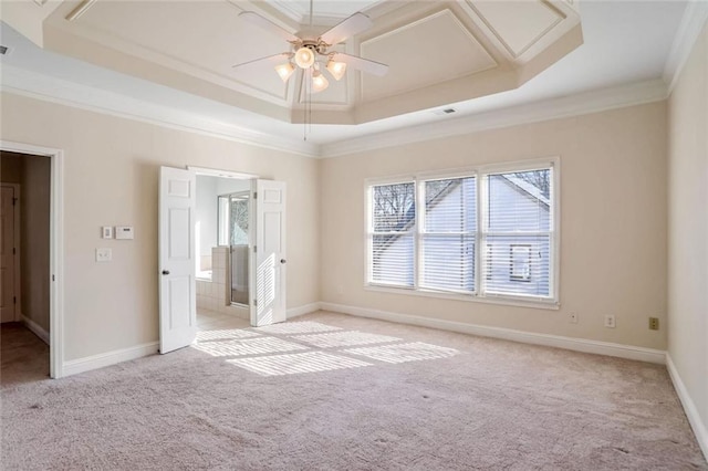 unfurnished bedroom featuring light carpet, baseboards, ornamental molding, and a raised ceiling