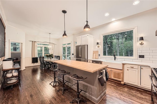 162 Taylor Ridge Way, Milton, GA 30004 - kitchen featuring stainless steel appliances, butcher block counters, a kitchen bar, dark wood-style flooring, and tasteful backsplash