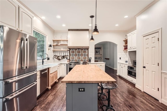 162 Taylor Ridge Way, Milton, GA 30004 - kitchen with appliances with stainless steel finishes, open shelves, arched walkways, a center island, and wooden counters