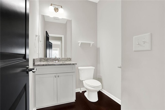 bathroom featuring hardwood / wood-style flooring, vanity, and toilet