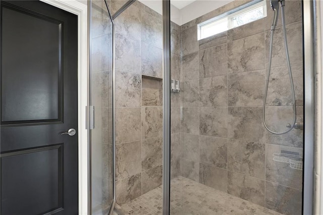 bathroom with a shower with door