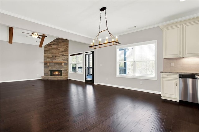 kitchen featuring dark wood-type flooring, a stone fireplace, lofted ceiling with beams, hanging light fixtures, and stainless steel dishwasher