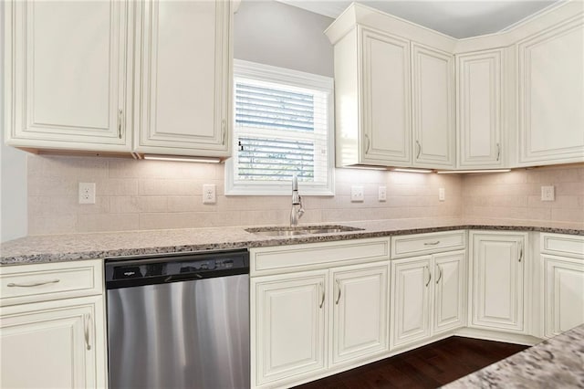 kitchen featuring dishwasher, stone countertops, sink, and decorative backsplash