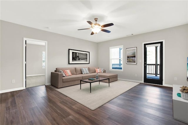 living room with ceiling fan and dark hardwood / wood-style flooring